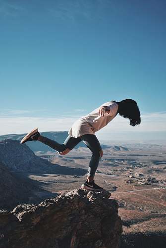 human woman in stands on mountain edge outdoors