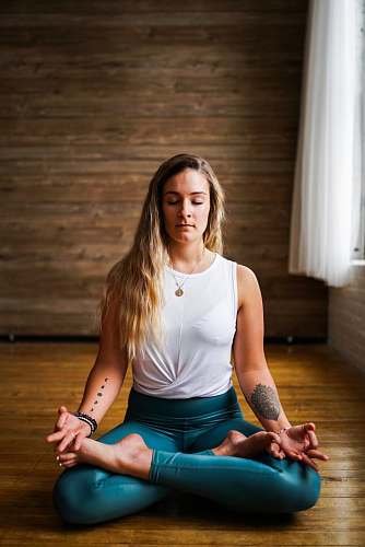 wood woman meditating inside room during daytime hardwood