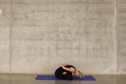 exercise woman sitting down on blue yoga mat sports