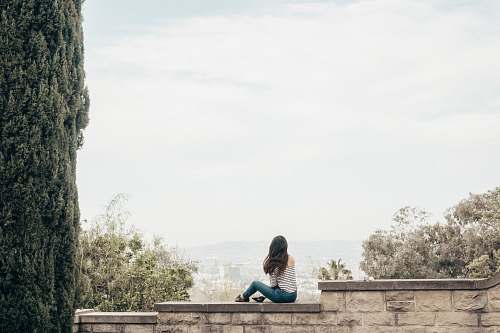 human woman sitting on concrete fence people
