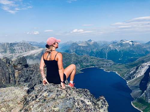 human woman sitting on mountain cliff people