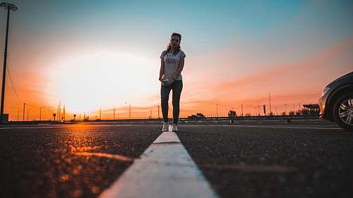 human woman standing on road during daytime automobile