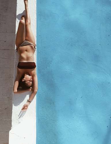 human woman sunbathing beside pool fitness