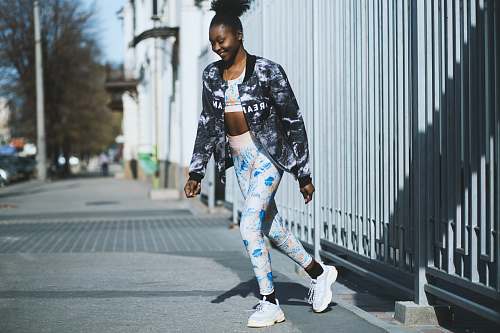 human woman walking near white metal gate people
