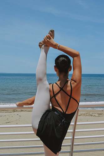 human woman wears gray leggings and black strap top close-up photography back