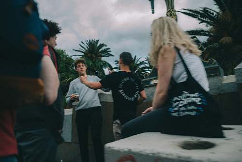 human woman witting on concrete facing men apparel