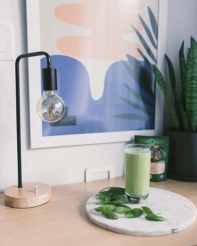 beverage clear drinking glass on top of table near desk lamp drink