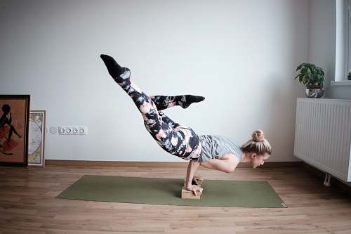 yoga woman balancing her body on olive-green mat dance pose
