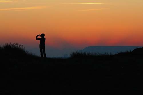 sunrise silhouette of person taking photo during sundown sunset
