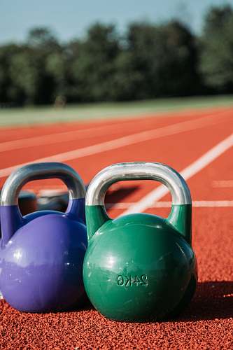 sports two green and purple kettle bells running track