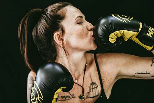 fitness woman kissing black leather boxing gloves woman