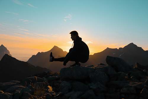 sunset silhouette on man on mountain silhouette