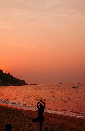 sea silhouette photo of woman doing yoga during sunset ocean
