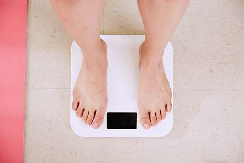 health person standing on white digital bathroom scale diet